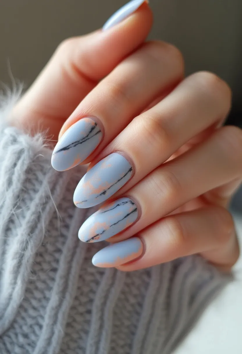 This nail design features a sophisticated and stylish look with medium length, almond-shaped nails. The color palette is predominantly light blue with soft, peachy accents, creating a serene and delicate appearance. Black marble-like streaks add an intricate and modern pattern to the design, enhancing its sophistication. The nails appear to have a matte finish, which suggests a gel or shellac nail treatment for its smooth and durable look. This design is versatile and elegant, suitable for seasonal themes such as winter or spring, or for special occasions where a chic and understated yet intriguing nail art is desired.