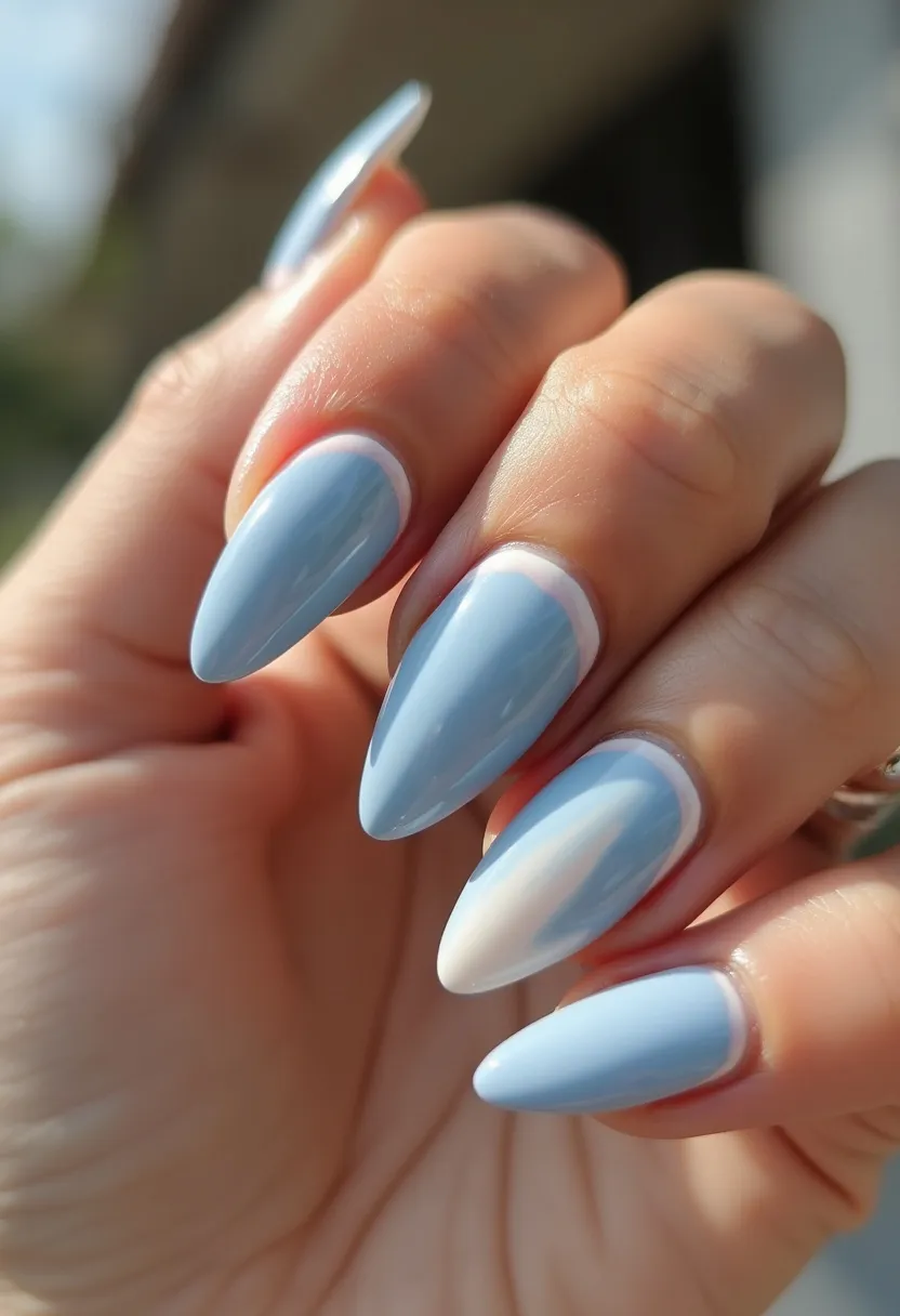 The nails feature an elongated almond shape with a smooth, glossy finish indicating a gel treatment. The color palette predominantly showcases a soft, pastel blue with an accent nail in white. Subtle, white, half-moon designs near the cuticles add a delicate touch of contrast. This design possesses a serene and airy feel, making it suitable for spring or winter seasons. The understated elegance coupled with the gentle hues aligns well for casual as well as formal occasions, offering a versatile yet sophisticated look.