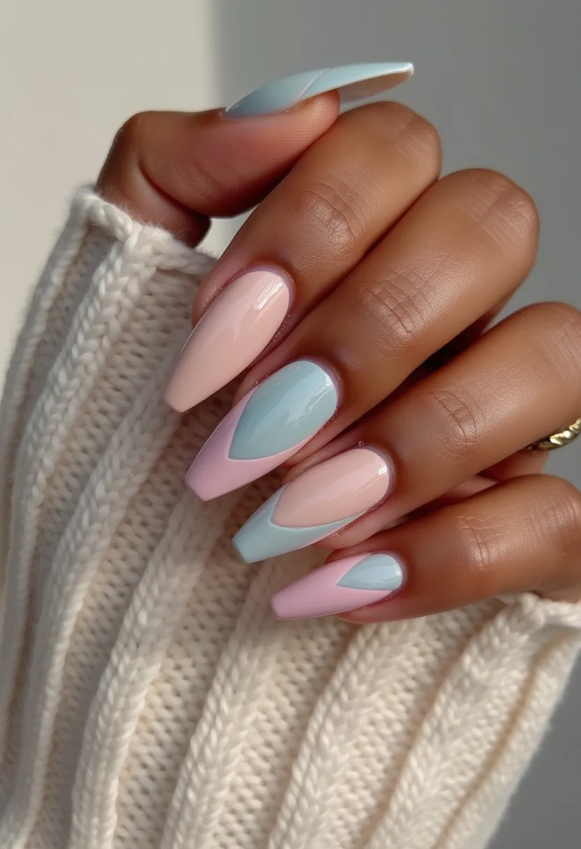 This nail design features a soft and delicate color palette of pastels, including baby pink and light blue. The nails are long and shaped in a stiletto style, which elongates the fingers and adds a touch of elegance. The design incorporates intricate patterns where the colors alternate in triangular overlays, creating a visually appealing and modern look. The glossy finish suggests a gel or shellac treatment, providing both durability and shine. This nail art is perfect for a soft, romantic look, potentially suitable for spring or a special occasion such as a wedding or a formal event.