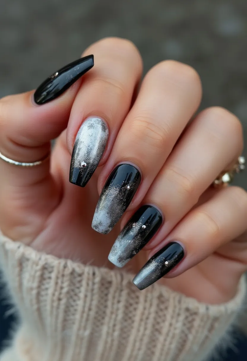 The nail design features a harmonious black and silver color palette, creating a sophisticated contrast. The nails are long and shaped into a tapered coffin style. This design incorporates intricate patterns with a metallic, smoky effect blending silver and black shades, giving a dramatic and upscale look. Small rhinestones add an extra touch of elegance at the base of each nail, making the design suitable for special occasions and possibly aiming for a winter or evening theme. The shiny finish suggests a gel treatment, which enhances durability and provides a sleek, polished appearance.