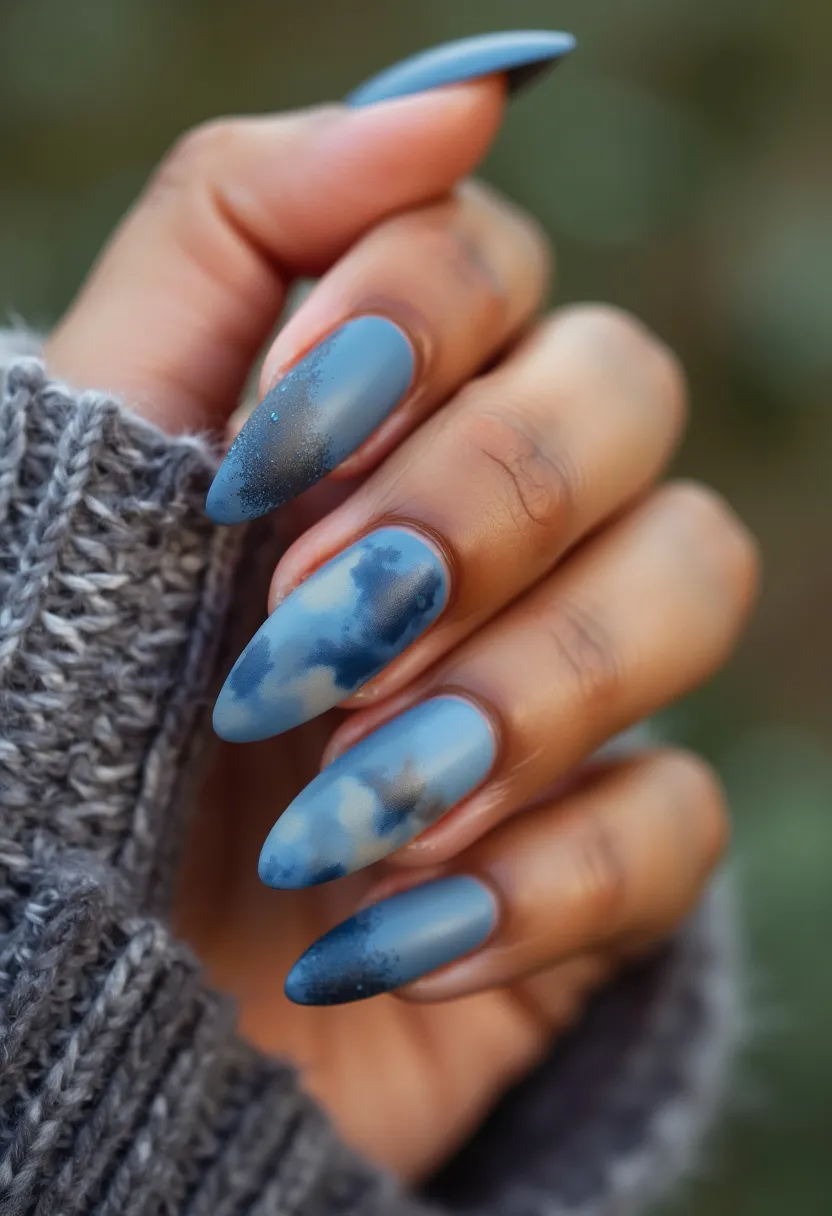 The nail design features an elegant and cohesive color palette with various shades of blue, ranging from soft sky blue to deeper navy blue, creating an intricate and visually pleasing gradient effect. The nails are shaped in a refined almond style, providing a sophisticated and elongating appearance to the fingers. The nail treatment used appears to be gel, ensuring a glossy and smooth finish that enhances the vibrancy of the colors. Intricately designed, the nails display a beautiful cloudy pattern, resembling a dreamy sky theme, adding a whimsical and artistic touch. These nails are personified with delicate, cloud-like details, making them a perfect choice for a winter or autumn season, evoking a sense of cozy and dreamy aesthetics.