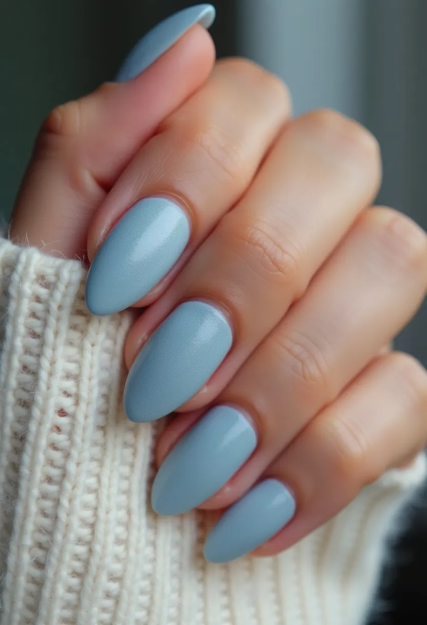 The nail design features an almond shape with a chic, uniform color palette of a soft, matte sky-blue polish. There are no intricate patterns or decorations, giving the nails a minimalist yet elegant appearance. The finish looks smooth and professional, suggesting that a gel or acrylic treatment could have been used to achieve the glossy and flawless look. The choice of color and understated design makes it versatile, suitable for a variety of seasonal themes, particularly for winter or spring, and it could be ideal for daily wear or special occasions that call for a subtle and sophisticated nail design.