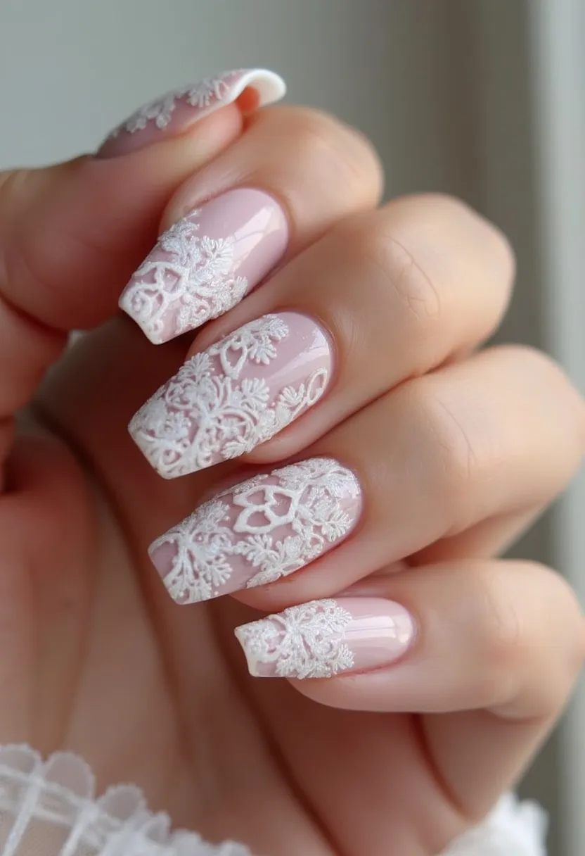 The nail design features a soft pink base color with an overlay of intricate white lace-like patterns. The nails are shaped into a square tip with a slightly rounded edge, which adds elegance to the overall look. The detailed white embellishments appear to be carefully applied over the pink polish, creating a delicate floral pattern that resembles lace. This design likely utilizes gel or acrylic techniques to achieve the high-gloss finish and the sculpted, three-dimensional decorations. The intricacy and delicacy of this nail art make it suitable for special occasions, particularly weddings, as it exudes a romantic and sophisticated feel.