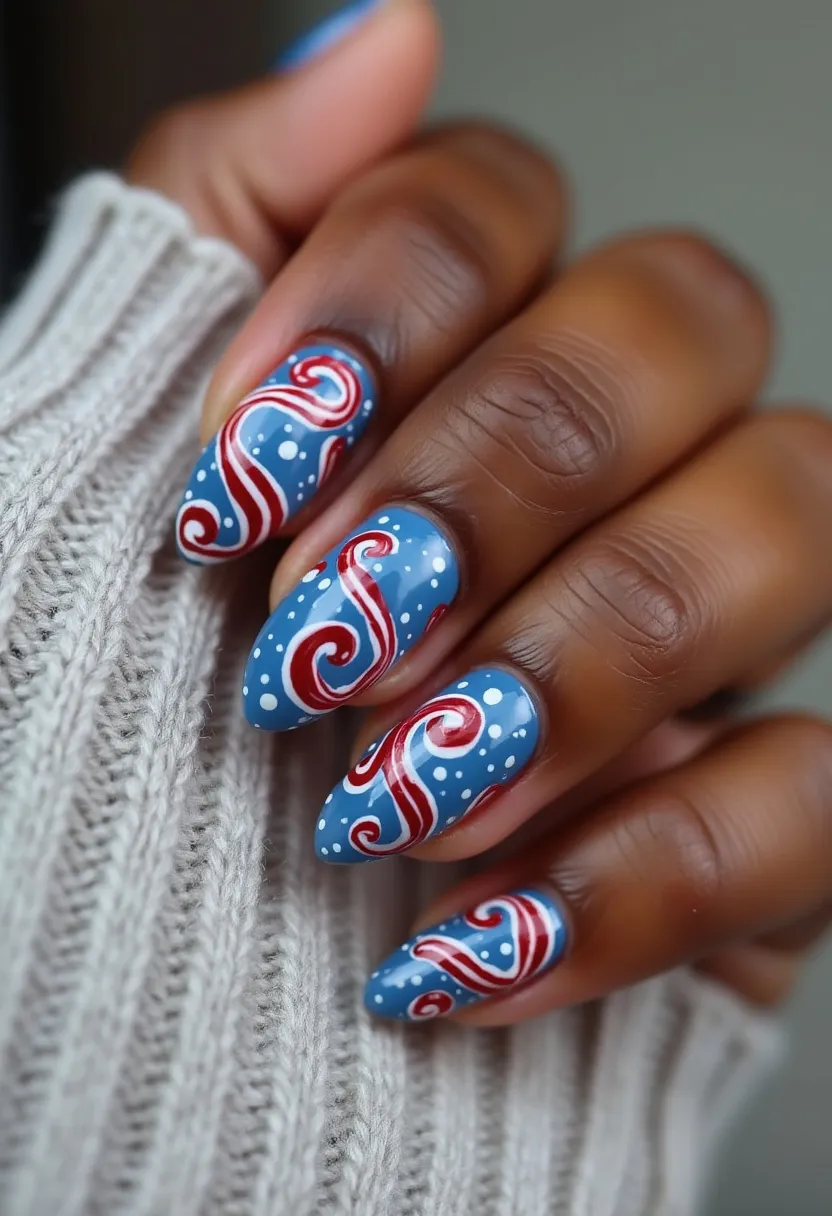 The nail design features a vivid and festive color palette consisting of blue, red, and white. The nails are shaped into a pointed almond form, giving them a sleek and sophisticated look. The primary color is a matte blue base, adorned with intricate red and white swirl patterns that resemble candy canes, indicative of a holiday or winter theme. White dots are scattered across the nails, enhancing the wintry feel, reminiscent of snowflakes. The detailed design appears to be created using a gel treatment, providing a glossy and long-lasting finish. These vibrant nails capture a festive and playful essence, perfect for celebrating the holiday season.