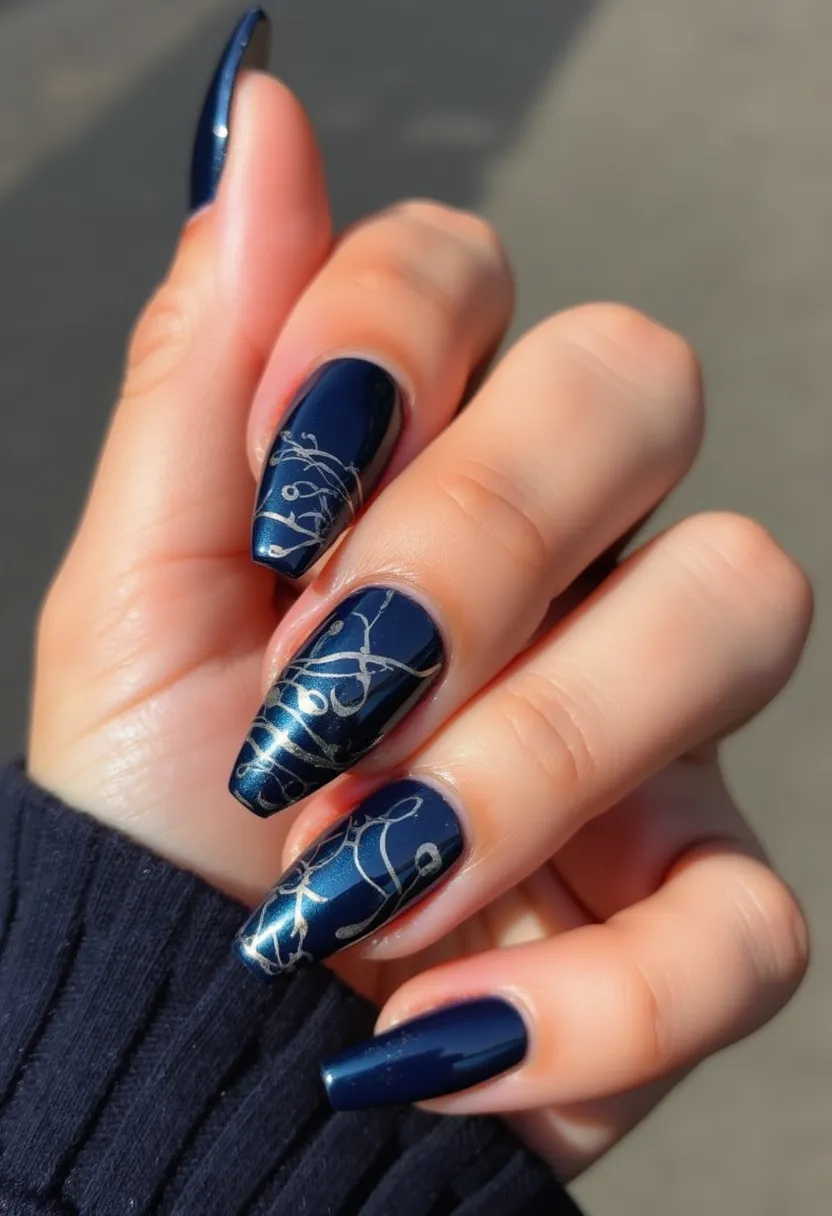 This nail design features a striking deep navy-blue color palette that exudes sophistication and elegance. The nails are shaped in a long, tapered coffin style, providing ample canvas for the intricate detailing. Each nail boasts delicate silver line art, which is gracefully intertwined across the surface, adding a refined and artistic touch. The silver patterns contrast beautifully against the dark background, creating a visually captivating effect. The glossy finish suggests a gel treatment, ensuring a durable and high-shine appearance. This design could be perfect for a chic, formal event or a winter-themed occasion due to its rich color and elegant artistry.