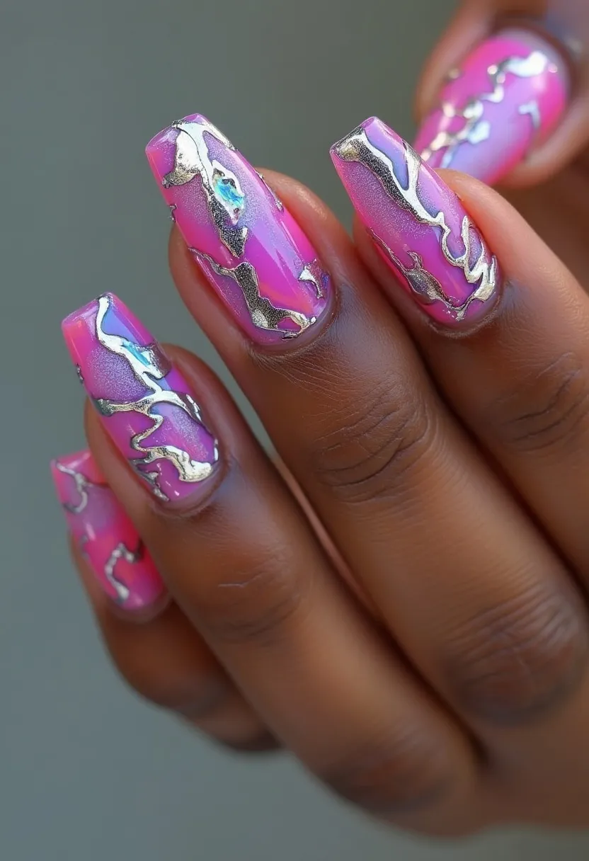 The nail design features a vibrant and eye-catching combination of pink and metallic silver. The nails are done in a long, coffin shape, providing ample space for the artistic design. The pink base color is accentuated with intricately applied metallic silver foil patterns which create an almost marbled effect. This design appears to be created with gel polish, giving the nails a glossy and lustrous finish. The use of metallic silver accents adds a touch of sophistication and glamour, making this design suitable for festive occasions or special events. The overall aesthetic is bold and trendy, maintaining a balance between playful and elegant.