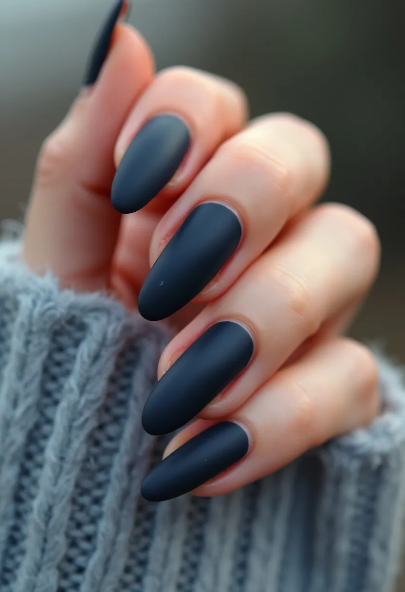 The nail design features a matte black color palette, giving the nails an elegant and sophisticated appearance. The nails are shaped in a stylish almond form, which elongates the fingers and adds a classic yet trendy touch. There are no intricate patterns or decorations, keeping the design simple and chic. The matte finish suggests that a gel or acrylic treatment might have been used to achieve this look, ensuring durability and a smooth, sleek texture. This manicure is versatile and suitable for numerous occasions, but it particularly resonates with the dark, cozy vibes appropriate for the winter or fall seasons.