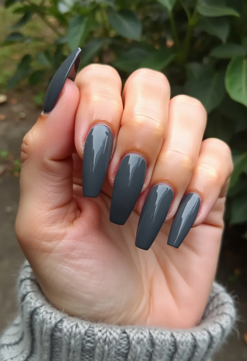 This nail design showcases an elegant and sophisticated look with a deep, glossy grey color palette. The nails are shaped into a fashionable coffin style, presenting a clean and elongated appearance. The high shine on the nails suggests a gel or shellac treatment, which provides a long-lasting and durable finish. There are no intricate patterns or decorations, highlighting the simplicity and sleekness of the design. This monochromatic scheme and refined shape are versatile, making it suitable for any season or special occasion, from casual to formal events.