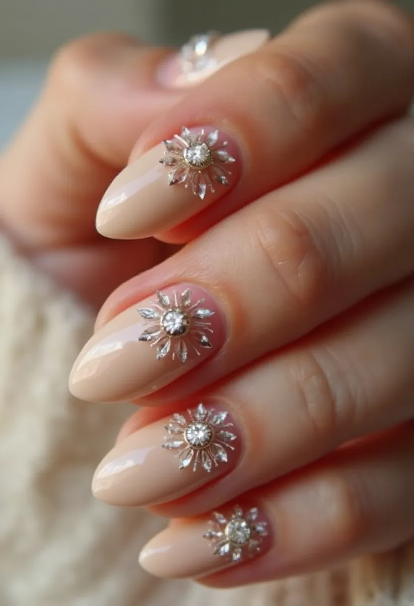 The nail design features a neutral beige color palette, lending a sophisticated and versatile look to the nails. The nails are shaped into a stylish almond form, emphasizing an elegant, elongated appearance. Each nail is adorned with intricate silver and crystal-like embellishments in a radial sunburst pattern, centered with a sparkling crystal, adding a touch of glamour and luxury. The treatment appears to be a gel manicure, given the high-gloss finish and durability of the decorations. This design is particularly well-suited for special occasions such as weddings or formal events, where a refined and polished look is desired. The radiant decorations provide a festive touch that could also align with seasonal celebrations or holiday themes.