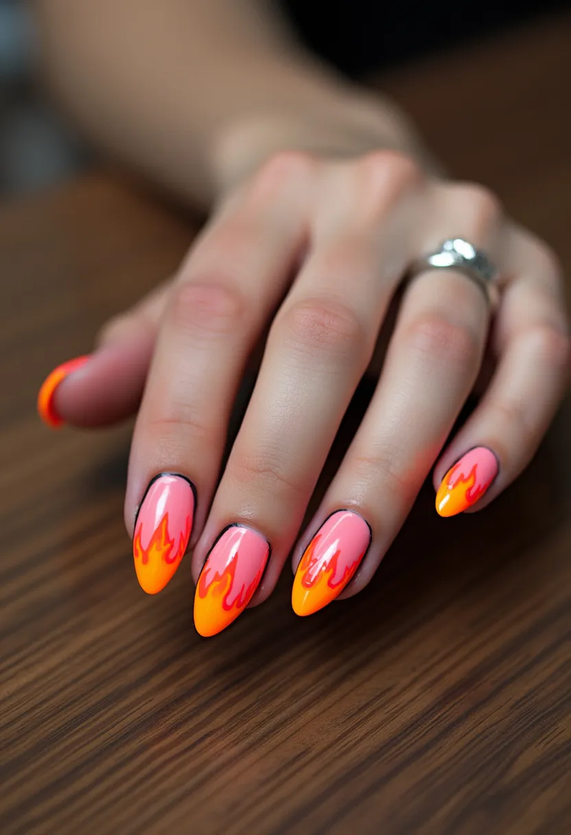 The nail design features a vibrant and fiery color palette incorporating shades of orange, yellow, and pink. The nails are shaped into a sharp, almond style, providing a striking canvas for the artwork. Each nail showcases a flame pattern, starting with a pink base that transitions into a bright orange and then yellow at the tips, creating a gradient flame effect. The design appears to be created using gel nail treatment, ensuring a glossy and durable finish. The fiery motif suggests a theme suitable for summer or perhaps a special event like a music festival, adding a dynamic and bold statement to the overall look.