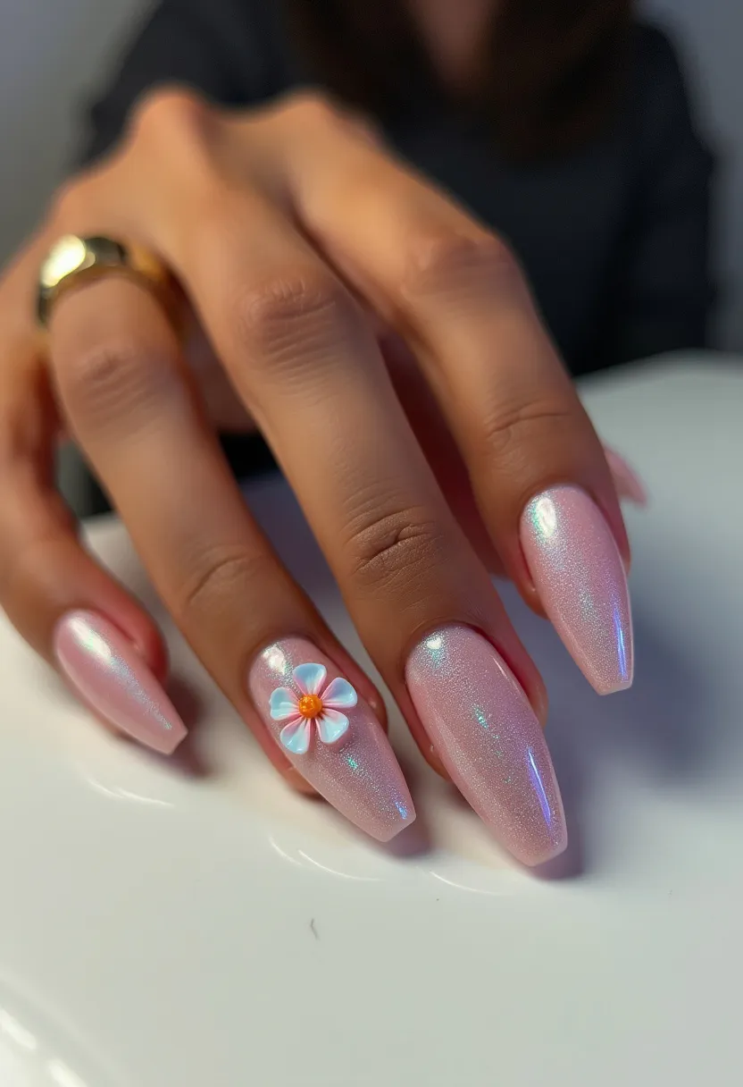 The nail design features a delicate, pastel pink color palette that emits a soft, pearlescent sheen. The nails are shaped into a long, tapered coffin style, giving them a sleek and elegant appearance. Most prominently, there is an intricate decoration on the ring finger, featuring a 3D flower with white petals and a yellow center, adding a touch of charm and detail to the otherwise minimalist design. The use of a shiny finish suggests that the treatment may be either gel or acrylic, known for providing a durable and glossy look. This design, with its floral motif, could be well-suited for springtime or a special occasion such as a wedding or a garden party.