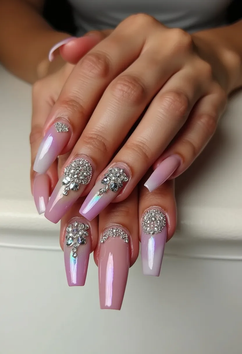 The nail design showcases a sophisticated and glamorous look with a color palette primarily consisting of soft pink and iridescent white hues, creating an elegant gradient effect. The nails are shaped in a long, coffin style, enhancing the elongation and elegance of the fingers. Intricate patterns are evident, featuring elaborate rhinestone embellishments on each nail, forming intricate and symmetrical floral-like patterns at the base near the cuticles. This design is likely achieved using gel or acrylic treatment, providing a durable and shiny finish. The abundant use of sparkly rhinestones and the refined color palette suggests a theme suitable for formal occasions, possibly ideal for weddings or festive events. The overall presentation exudes luxury and meticulous craftsmanship, making it a stand-out nail design for special celebrations.