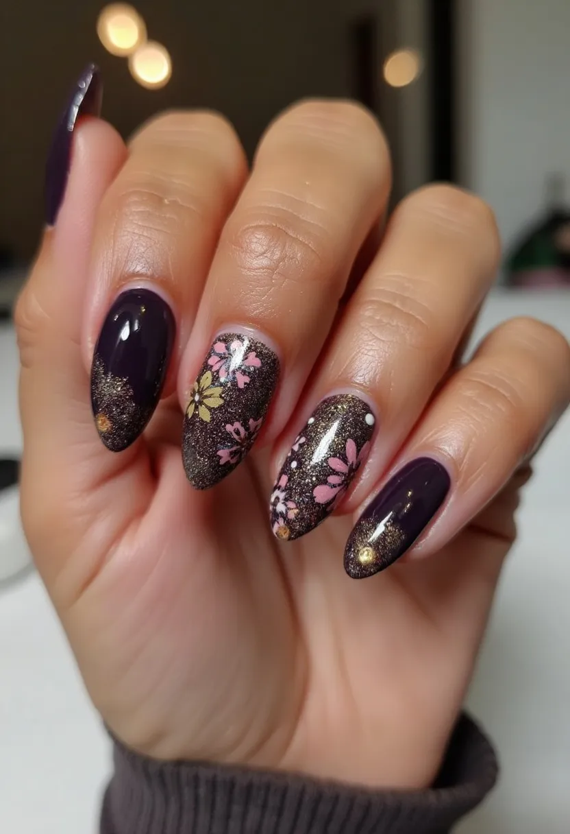 This nail design showcases a sophisticated color palette featuring deep plum and sparkling gold hues. The nails are shaped into a graceful almond form, offering a chic and elongating effect. Intricate floral patterns in soft pinks, white, and yellow are meticulously painted on some nails, adding a touch of delicate charm that hints at a possible spring or celebratory theme. The designs appear to be crafted with gel polish, giving a glossy, reflective finish that enhances the overall allure. Additionally, subtle gold embellishments on selected nails add a luxurious and festive element to the design.