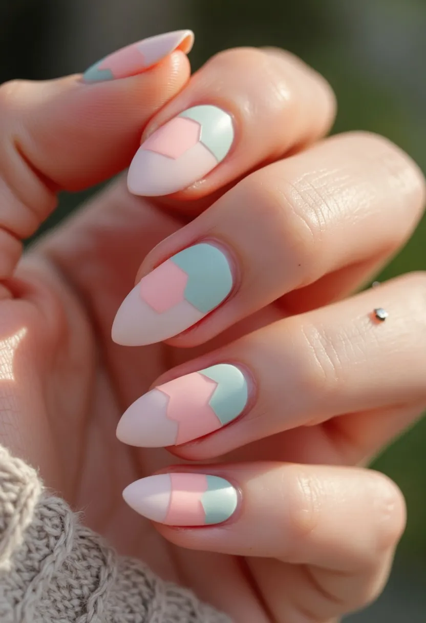 The nail design features a pastel color palette with soft shades of pink, mint green, and creamy white. The nails are shaped in an almond fashion, giving them an elegant and elongated appearance. Each nail showcases a geometric block pattern, combining the three colors in overlapping sections, creating a modern and artistic look. The treatment appears to be a smooth application, possibly achieved using gel polish, which offers a glossy and durable finish. The intricate design and pastel hues suggest a seasonal theme appropriate for spring, reflecting a light and fresh aesthetic suitable for special occasions or everyday wear.