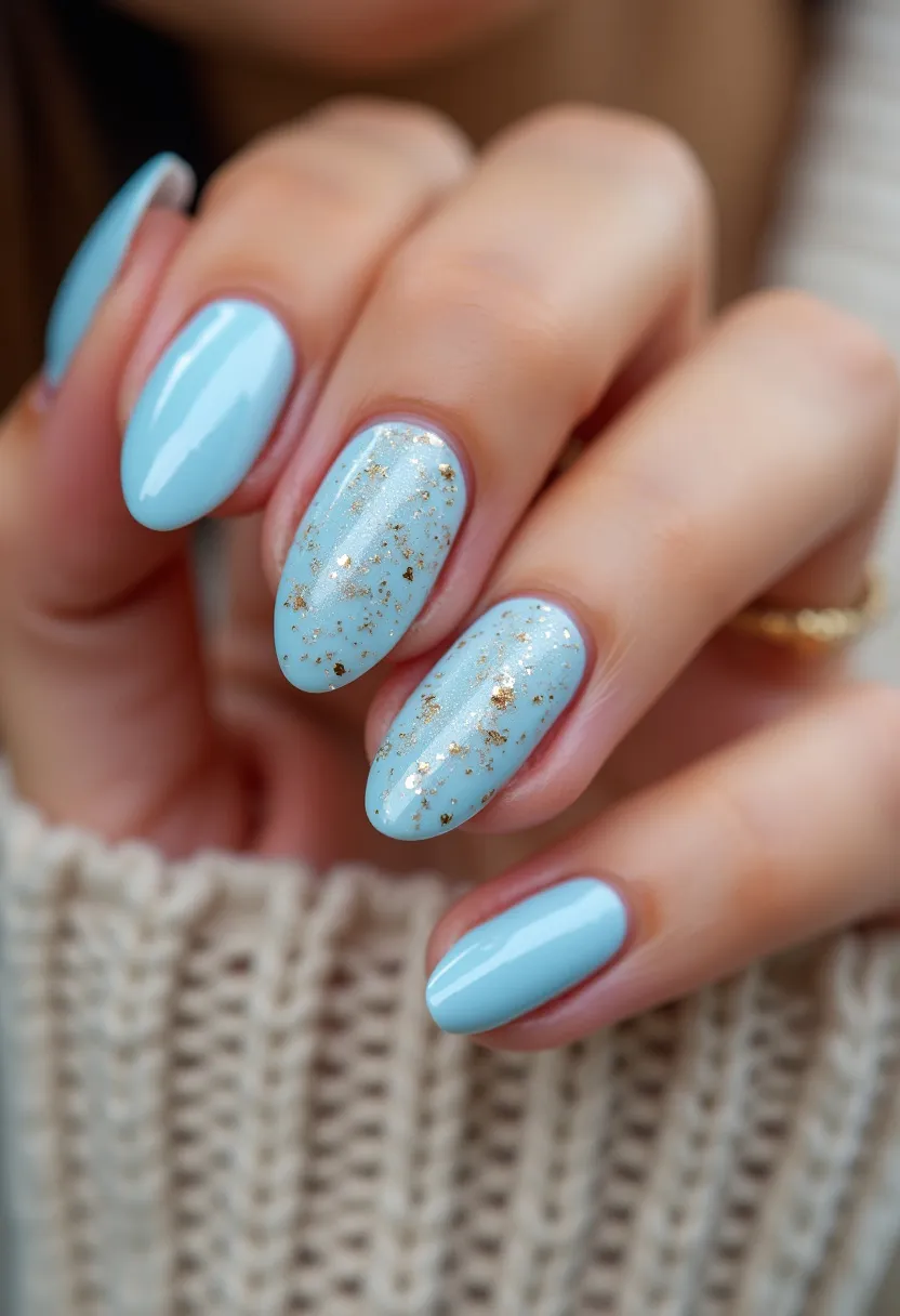 The nail design showcases a soft and serene baby blue color palette, perfectly suited for a fresh and delicate look. The nails are shaped in an elegant almond style that accentuates the fingers' natural length. Adding a touch of sophistication, some nails feature intricate gold leaf flakes embedded within the polish, creating a luxurious, eye-catching contrast against the pastel blue background. The treatment appears to be a gel polish, providing a smooth and glossy finish that enhances the design's overall shine. This nail art is not bound to any specific season or occasion but could be ideal for both a casual day out and a more formal event, thanks to its versatile yet chic appearance.