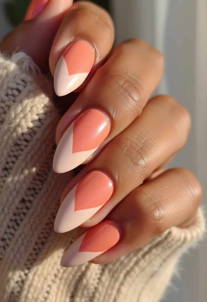 This nail design features a vibrant and trendy color palette of peachy orange and soft nude pink. The nails are shaped into an elegant almond form, providing a sophisticated and elongated appearance. They are adorned with a geometric pattern, which displays a reverse French manicure style with the bright peach shade forming a triangle at the cuticle area and extending towards the tip, contrasted by the nude pink base. The finish is glossy, indicating a possible gel treatment, which adds durability and a high-shine effect. This design can be fitting for both everyday wear and special occasions, offering a chic and modern aesthetic that complements various seasonal themes, particularly suitable for spring or summer.