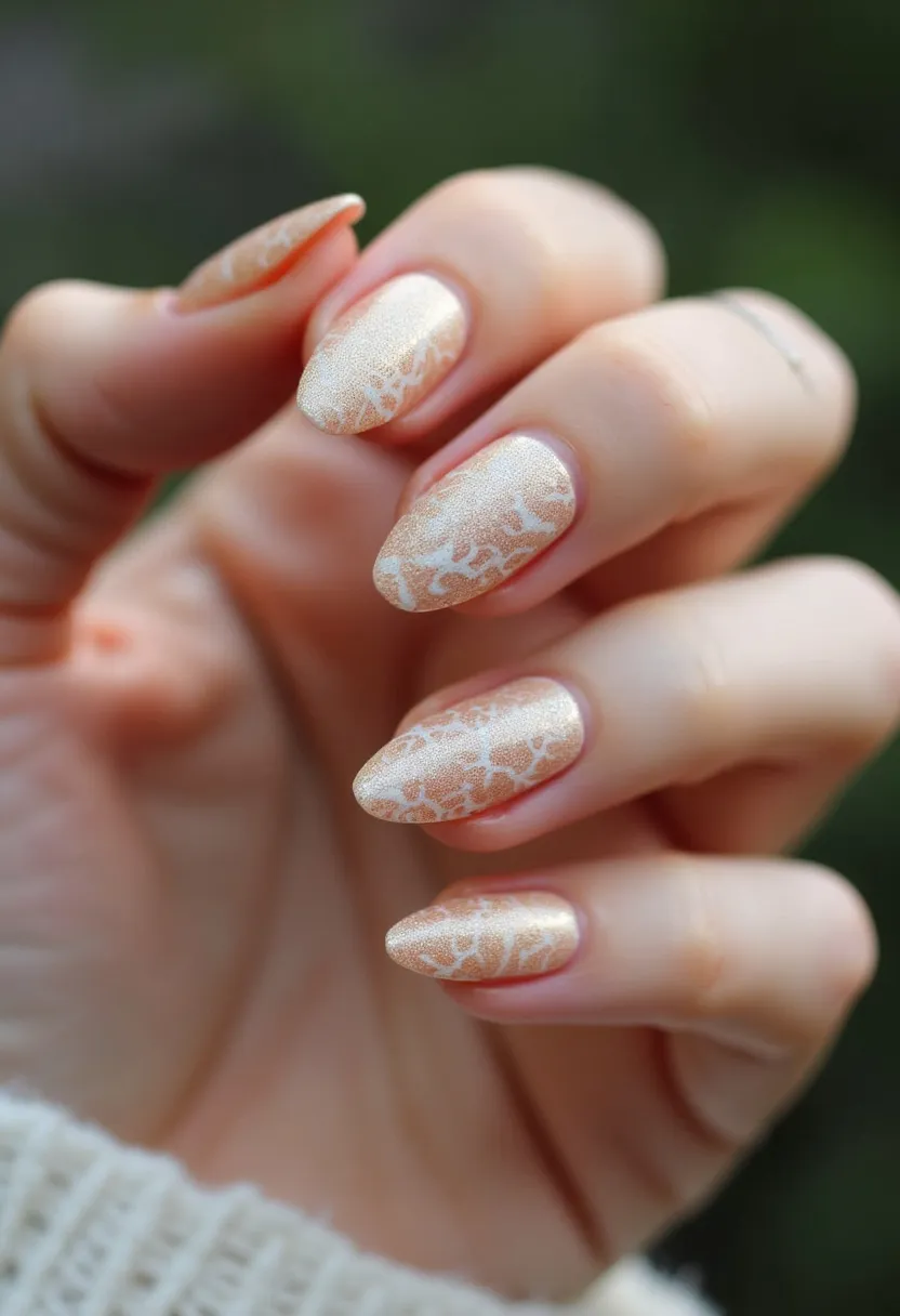 The nail design features an elegant and sophisticated palette, predominantly showcasing a pearlescent beige or champagne color. The nails are almond-shaped, providing a feminine and elongated look to the fingers. Intricate white lace-like patterns overlay the nails, adding a delicate and refined touch to the design. The finish seems to be achieved through gel treatment, giving the nails a smooth and glossy appearance. This nail art is versatile and can complement various seasonal themes or special occasions such as weddings, formal events, or holiday celebrations, emphasizing classic and graceful aesthetics.