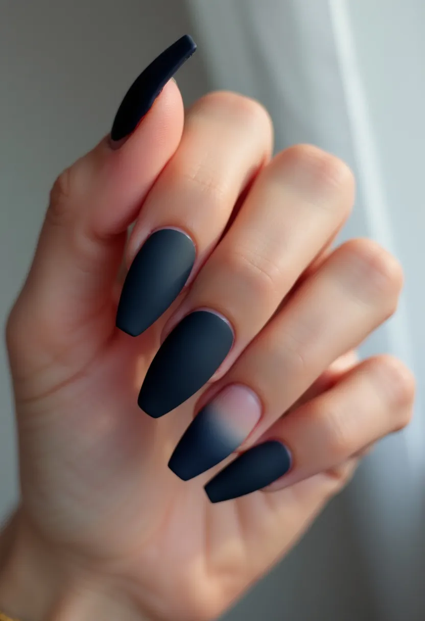 The nail design features a matte black color palette, applied to long, almond-shaped nails. The nails appear to have a sleek and smooth finish, indicating the use of a matte gel polish. The design is minimalist, with a solid matte black color without additional patterns or decorations. The matte black finish provides a modern and chic look, suitable for any season or special occasion. The choice of a matte finish adds a sophisticated touch to the overall design, making it elegant and versatile.