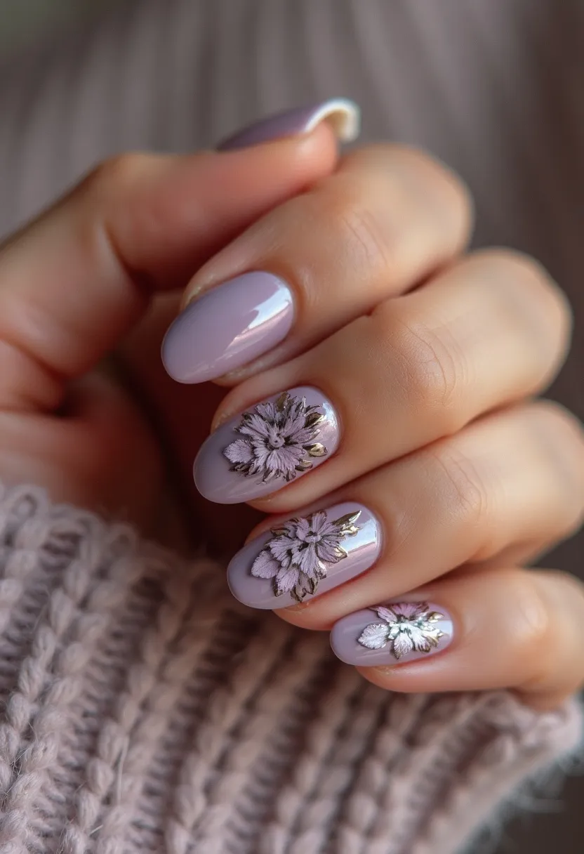 This nail design showcases a soft lavender color palette with a glossy finish, indicating a possible gel treatment. The nails are shaped in a short to medium almond form, providing an elegant and subtle look. Two accent nails on each hand feature intricate floral patterns in a muted lilac hue with delicate gold detailing, adding a touch of sophistication to the design. These floral accents are likely created using a combination of nail art techniques like stamping or hand-painting. The overall look is delicate and sophisticated, suitable for the spring season or special occasions such as weddings or formal events.