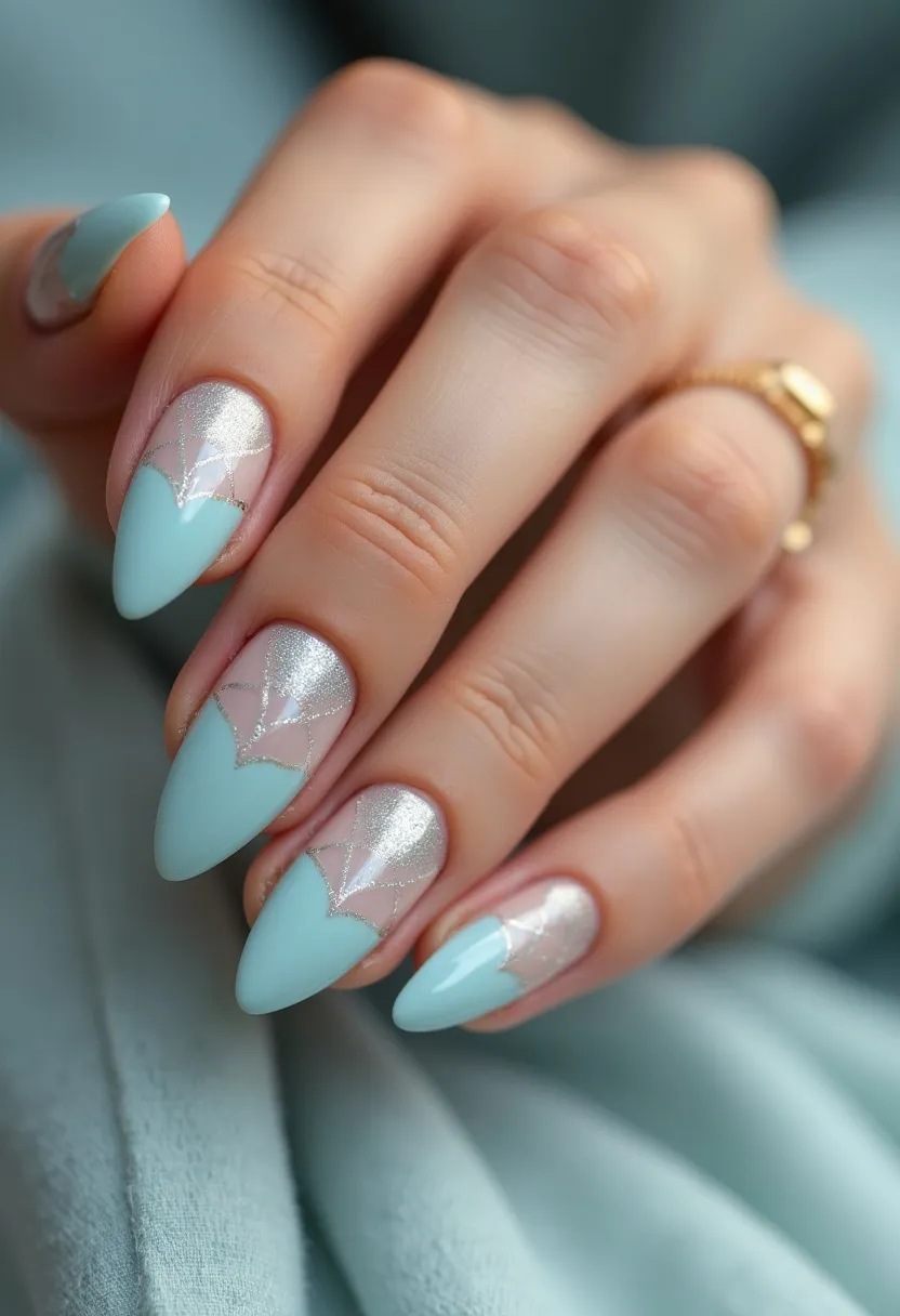 The nail design features an elegant color palette composed primarily of light blue and silver. The nails are shaped in a stiletto style, characterized by their long and pointed tips. The intricate pattern includes a geometric design near the cuticle area, with silver glitter accents that transition smoothly into the light blue tips. The style appears to employ gel treatment, providing a smooth and glossy finish. This sophisticated look can be suitable for winter occasions due to the frosty color scheme or festive events where a touch of glamour is desired. The design effectively combines simplicity with ornate detailing, making it visually appealing and stylish.