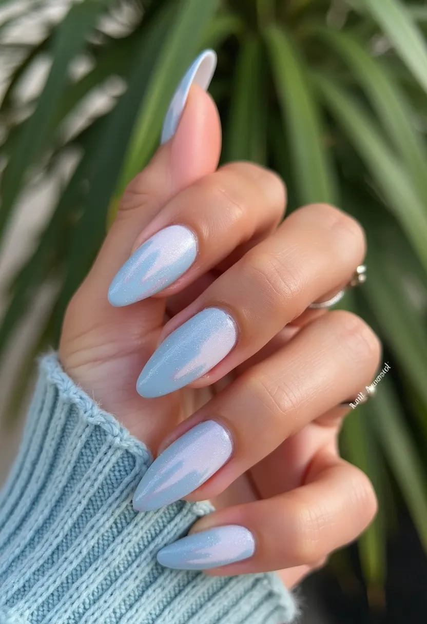 The nail design features a soft, pastel color palette with a prominent use of light blue as the base color. The nails are in an almond shape, adding a touch of elegance and elongation to the fingers. Intricate patterns are visible, with a gradient effect that subtly transitions from light blue near the tips to an almost ethereal, shimmery white towards the base. Complex details include a glossy finish that suggests the use of gel treatment, providing both durability and a glass-like shine. The design evokes a wintry, icy theme likely suitable for the winter season or special occasions like holiday parties due to its frosty, glistening appearance.