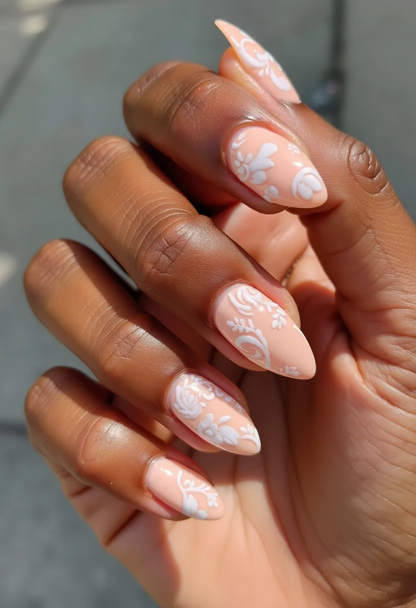 This nail design features a soft and elegant look with a pastel peach color as the base, accentuated by intricate white floral patterns. The nails are shaped into an almond form, giving a graceful and sophisticated aesthetic. The floral patterns are delicately detailed, creating a lace-like effect that adds a touch of romance and femininity to the nails. The polish appears smooth and glossy, indicating a gel treatment, which provides a shiny finish and long-lasting durability. This design is perfect for special occasions like weddings or spring celebrations, with its fresh and floral themes evoking a sense of renewal and beauty. The overall look is both stylish and timeless, making it suitable for various seasonal events.