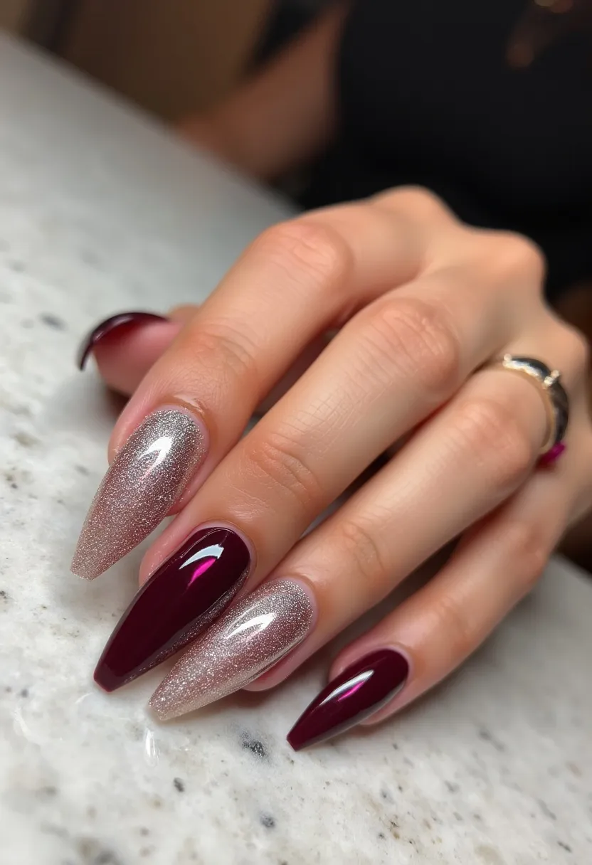 The nail design features an elegant almond shape and a sophisticated color palette. Rich burgundy forms the primary color, complimented by an accent of glittery silver on two of the nails. The nails appear to be treated with a glossy finish, which is indicative of a gel or shellac treatment due to the high shine and smooth surface. The combination of deep burgundy and sparkling silver creates a chic and festive look, making it suitable for the winter season or special occasions such as holiday parties or elegant events. The glittery silver accent adds a touch of glamour and contrast to the solid, dark burgundy nails, creating a refined and tasteful design.