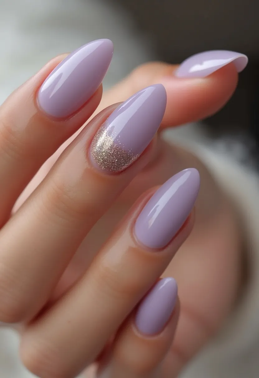 The nail design features a soft, pastel lavender color palette with a glossy finish, indicating a possible gel or shellac treatment. The nails are shaped in a pointed almond style, providing an elegant and chic look. Each nail is uniformly painted in the same lavender hue, except for one accent nail that incorporates a touch of sparkle with gold glitter at the base, which gradually fades towards the middle, adding a subtle yet eye-catching detail. This design is versatile and can be worn for various seasons and occasions, making it suitable for both everyday wear and special events. The addition of the glitter accent elevates the overall aesthetic, giving it a touch of glamour.