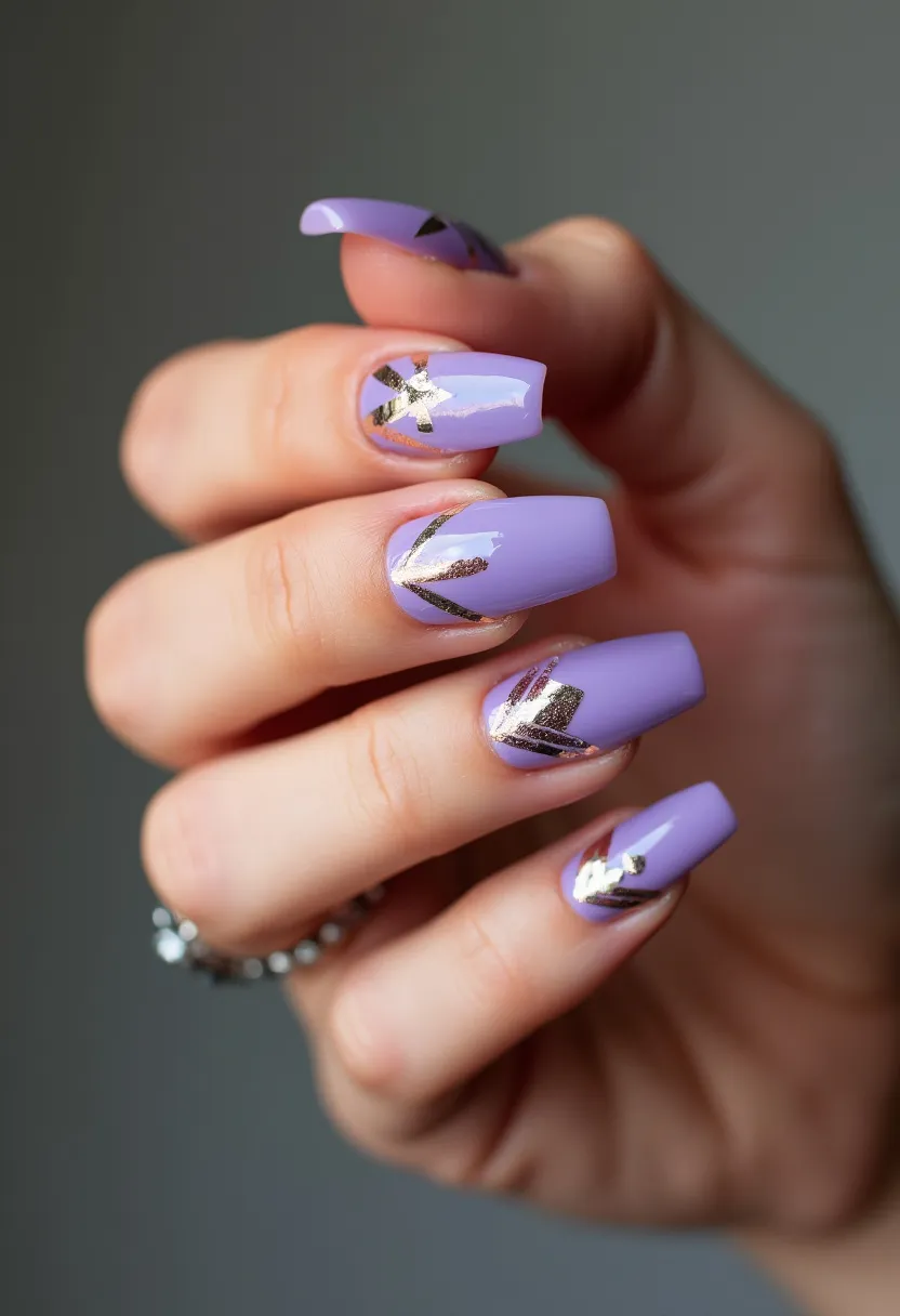 The nail design features an elegant lavender color palette, showcasing a sophisticated long coffin shape. Each nail is adorned with intricate and stylish gold foil accents arranged in geometric patterns, creating a striking contrast against the soft base color. These nails likely feature a gel treatment, as evidenced by their glossy, smooth finish. This design with its pastel hue and metallic details suggests a suitable fit for special occasions, such as weddings or formal events, and might also resonate well with spring and summer seasonal themes.