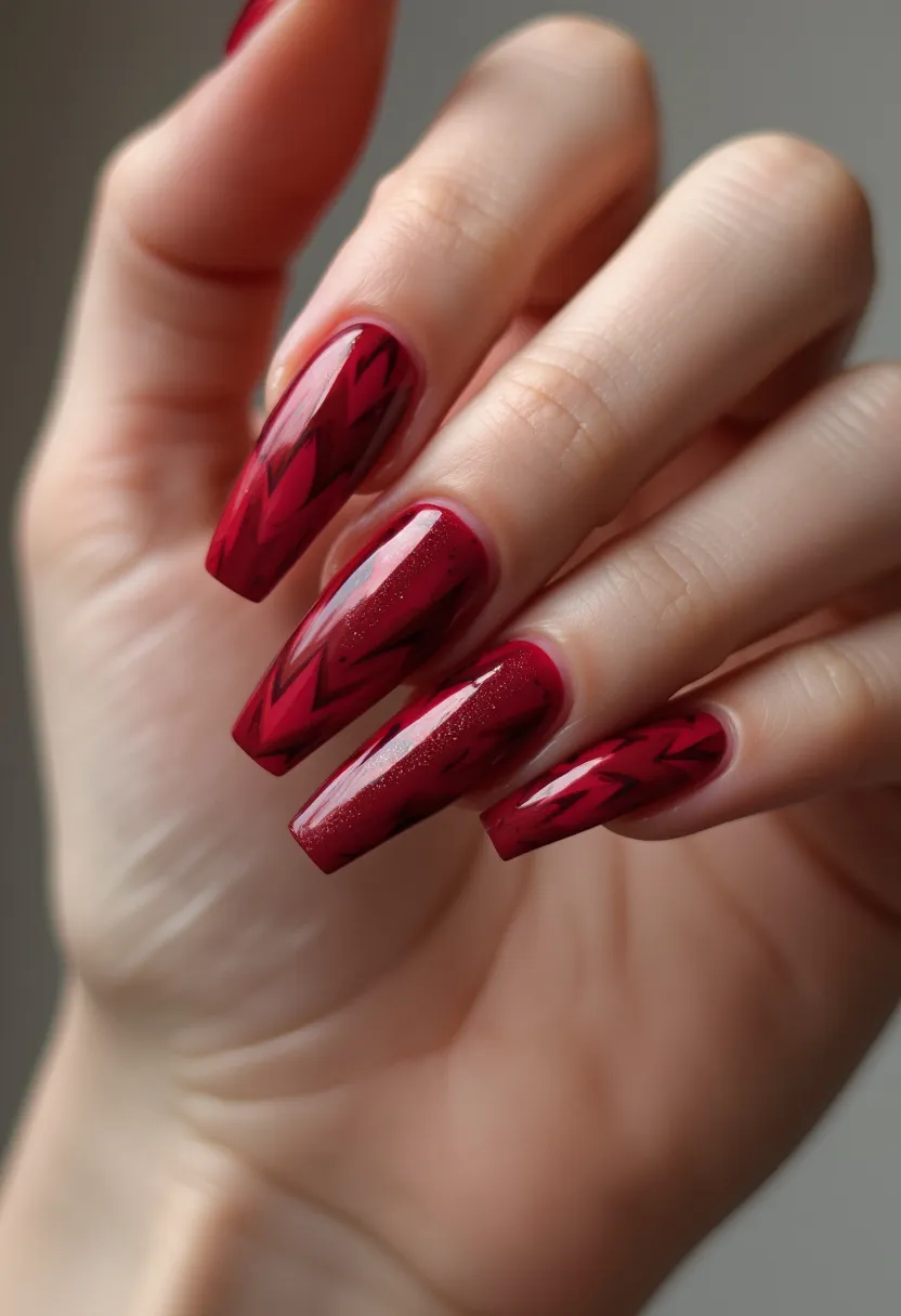 The nail design features long, coffin-shaped nails with a deep, rich red color palette. The nails exhibit intricate, angular patterns in a darker shade of red, creating a striking contrast against the base color. The finish appears glossy and smooth, suggesting a gel or acrylic treatment, enhancing the durability and shine of the manicure. Small, subtle sparkles are meticulously embedded in the design, adding an extra touch of elegance and sophistication. The overall aesthetic leans towards a festive, possibly holiday-themed or special occasion look, with its bold color and eye-catching patterns.