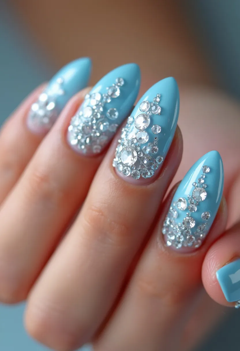 This nail design features a stunning powder blue base color that covers the entirety of the nails. The nails have a stiletto shape, characterized by their sharp, pointed tips. Adding a touch of glamor and sophistication, the nails are adorned with an intricate pattern of variously sized clear rhinestones. These rhinestones are concentrated more densely toward the tips, creating a cascading effect as they spread toward the base of the nails. The shine of the rhinestones against the soft blue backdrop provides a striking contrast, making this design particularly dramatic and eye-catching. Given the glossy finish and the professional application, it appears to be a gel nail treatment. This design is perfect for special occasions such as weddings, parties, or festive celebrations, providing an elegant and luxurious aesthetic.