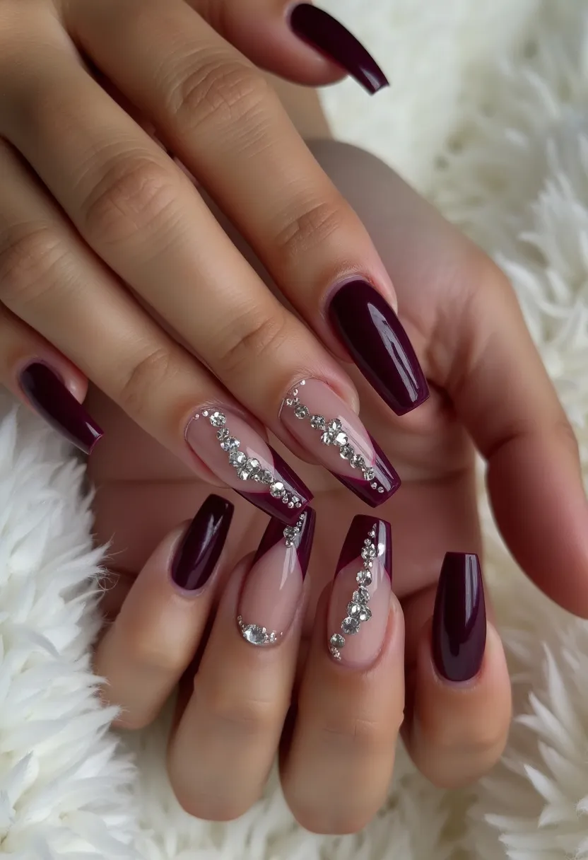 This nail design features a sophisticated and elegant color palette dominated by a deep, rich burgundy shade. The nails are shaped into a long, squared form, providing a modern and sleek appearance. Two of the nails on each hand incorporate intricate patterns; a clear base is adorned with a diagonal burgundy tip, embellished with a graceful array of sparkling, silver rhinestones that create a sophisticated, glimmering effect. This design is primarily achieved through gel nail treatment, which offers a glossy and durable finish. The overall look exudes a festive and chic vibe, ideal for a special occasion or a glamorous seasonal event.