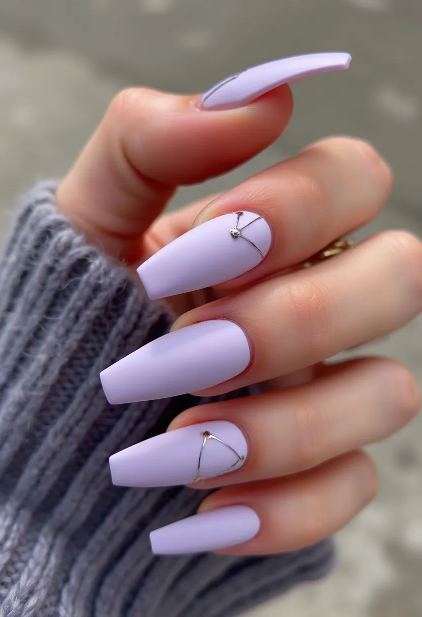 This nail design features a soft lavender color palette, creating a serene and elegant look. The nails are shaped in a long coffin style, providing a sophisticated and modern appearance. A notable detail is the intricate metallic silver wire decoration on one nail, which forms a delicate geometric pattern and is accented with tiny gemstone embellishments. The nail treatment appears to be gel, given the smooth and glossy finish. This design's subtle yet intricate details make it suitable for special occasions or as a chic everyday look. The overall aesthetic is calm and refined, perfect for the spring season or any time you want a touch of casual elegance.