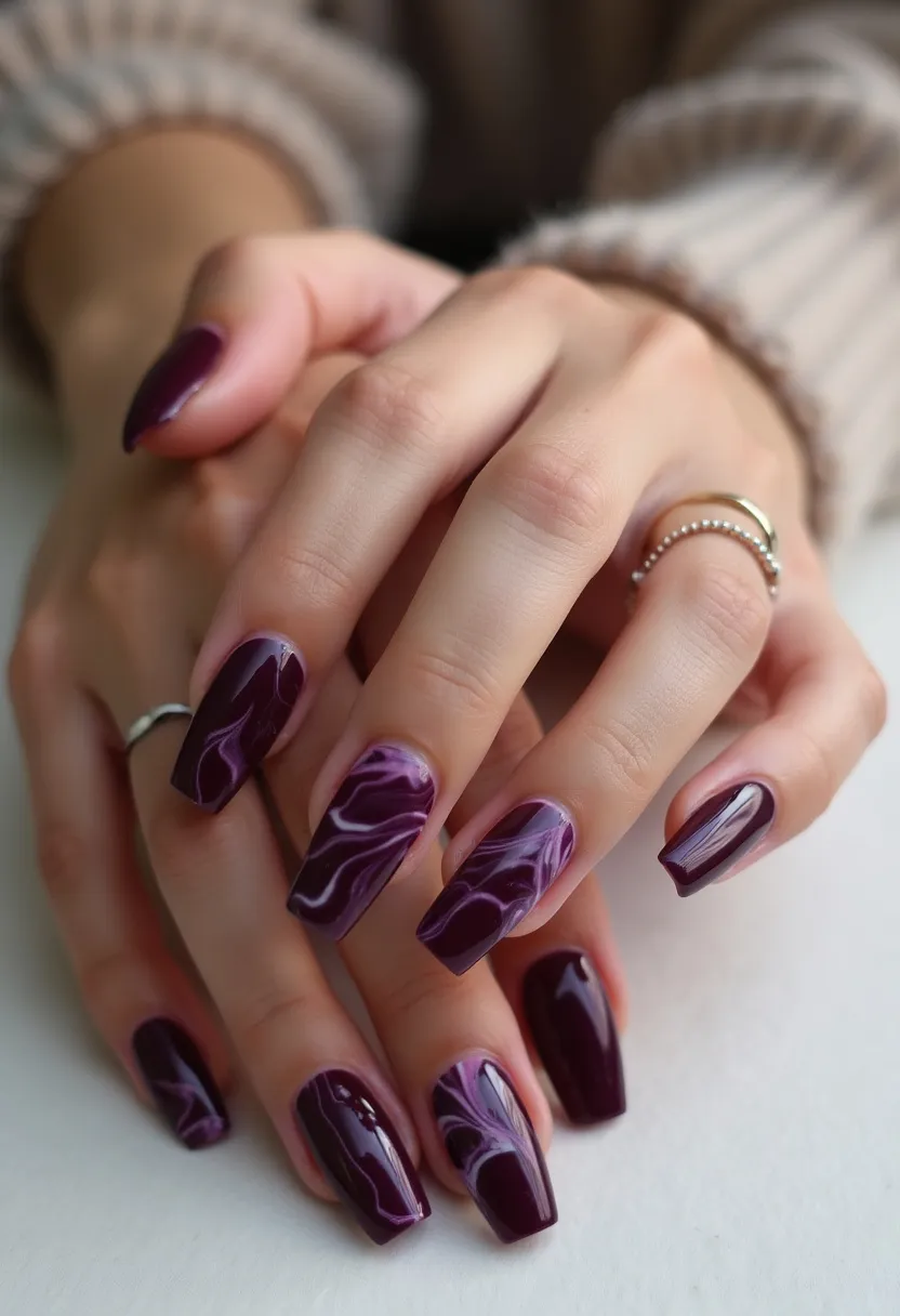 The nail design features a rich, deep purple color palette with a glossy finish, indicative of a gel treatment. The nails are shaped in a refined, squared-off style, providing a sophisticated look. Some of the nails exhibit an intricate marbling pattern, blending shades of purple and white to create a fluid, dynamic effect. Unique details such as the marbled design add a personalized touch, making the nails suitable for both everyday elegance and special occasions. This design's dark and warm hues make it particularly fitting for the autumn and winter seasons.