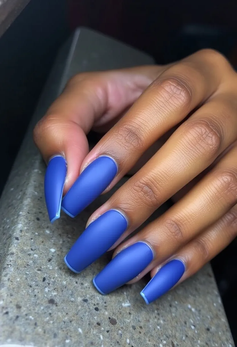 This nail design showcases a striking matte blue color palette, creating a bold yet sophisticated look. The nails are long and shaped in a coffin style, which accentuates their elegant appearance. The manicure treatment looks like it might be achieved with gel, ensuring a smooth and enduring finish. There aren't any intricate patterns or additional decorations, allowing the vibrant blue color to stand out prominently. This style could be fitting for various special occasions, adding a touch of modern flair to an ensemble, and could be especially fitting for winter or themed events that call for a pop of dramatic color.