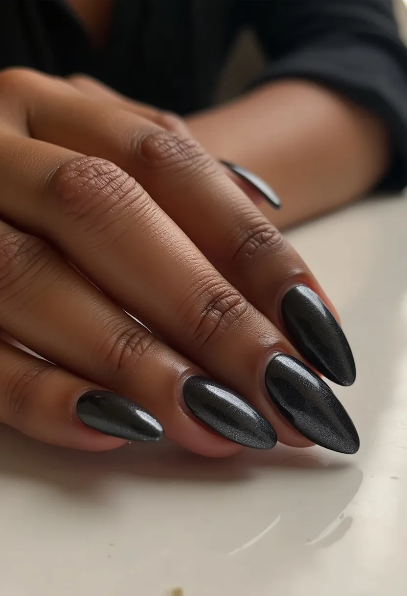 The nails feature a striking design with an elegant gray-matte color palette, giving them a sophisticated and versatile appearance suitable for various settings. The nails are shaped into a pointed almond form, which adds an element of elegance and elongates the fingers. The surface has a smooth, shiny finish, likely achieved through a gel nail treatment, providing durability and a glossy sheen. There are no visible intricate patterns or decorations, maintaining a minimalist and refined aesthetic. This nail design is versatile and could be fitting for a range of occasions, from professional environments to special events.