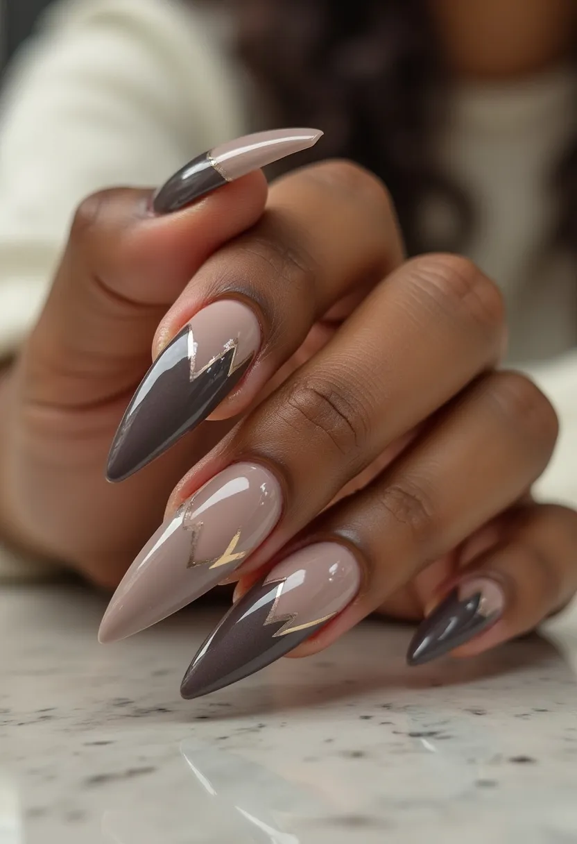 The nail design features a sophisticated color palette that includes neutral beige and deep charcoal gray hues. The nails are shaped into a sharp stiletto form, contributing to a bold and elegant appearance. Each nail showcases intricate patterns with a modern geometric design, highlighting sharp, angular lines that create a striking contrast between the beige and dark gray colors. A subtle touch of metallic gold accentuates the geometric pattern, adding a hint of glamour. The high-gloss finish suggests that the nails have been treated with a gel polish, ensuring durability and a sleek, shiny look. This design's clean lines and neutral yet bold colors make it suitable for various occasions, from everyday wear to special events, with a contemporary and stylish appeal.