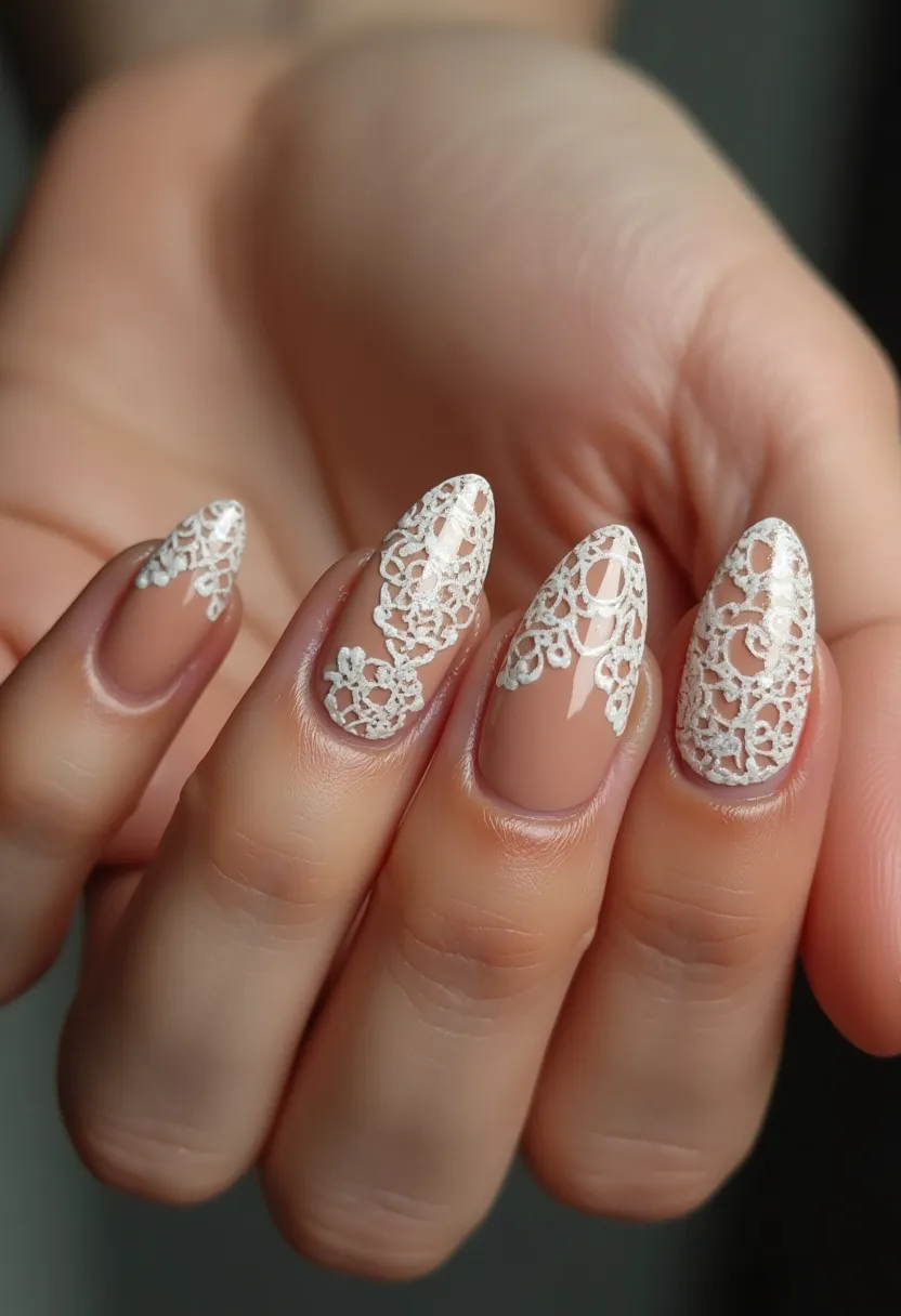 The nail design features a sophisticated almond shape, complemented by a neutral base color that seamlessly blends with the natural nail. The palette includes a soft nude as the foundation, topped with intricate and delicate white lace patterns that add a touch of elegance and femininity to the overall look. The lace design varies slightly on each nail, creating an artistic and custom effect that is detailed and visually stunning. The nails appear to have a glossy finish, commonly associated with gel treatments, providing a long-lasting and polished appearance. This design could be well-suited for special occasions such as weddings or formal events due to its refined and graceful aesthetic.