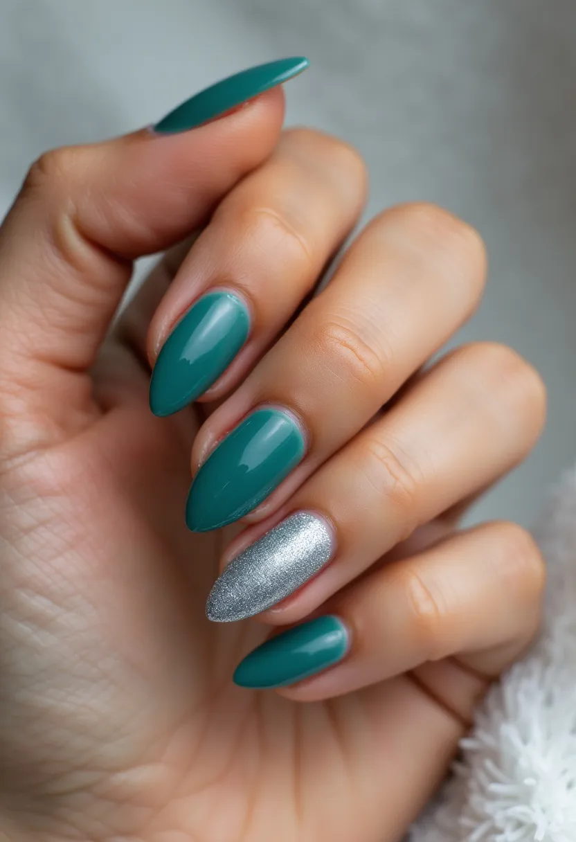 The nail design in the image features a sophisticated and elegant look with a striking color palette. The nails are shaped in a classy almond style, offering a sleek and refined appearance. The color scheme includes a rich, teal hue, applied to four of the nails, creating a unified and bold statement. One accent nail, standing out prominently, is coated in a shimmering silver glitter, adding a touch of glamour and contrast to the overall design. The likely treatment used for this nail design is gel, given the glossy and smooth finish that enhances the vibrancy of the colors. This nail design does not appear to cater specifically to a seasonal theme or special occasion, making it a versatile choice suitable for various events and everyday wear.