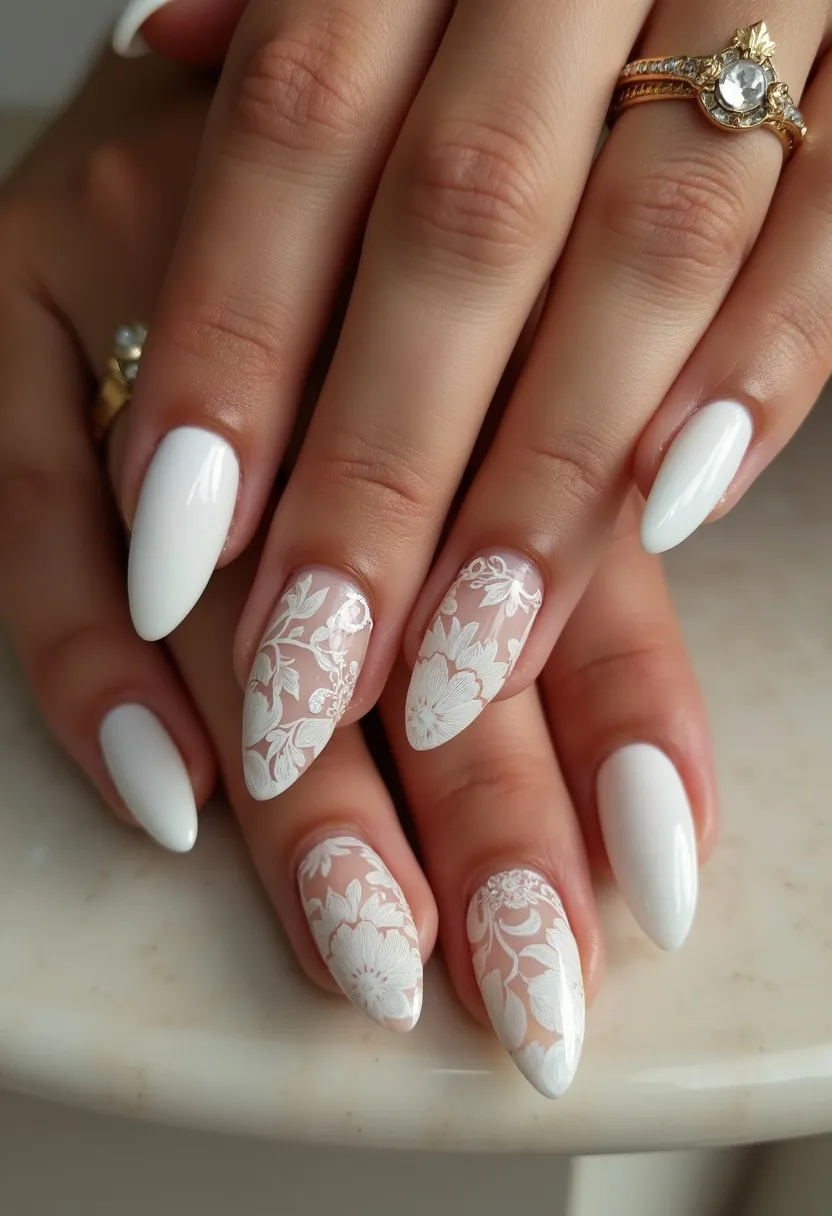 The nail design features an elegant and sophisticated palette predominated by a clean, classic white color. The nails are almond-shaped, enhancing the overall chic appearance. Most nails are fully coated in glossy white, while a couple of accent nails showcase intricate white floral lace patterns over a clear base. The intricate floral details suggest a delicate, romantic vibe, ideal for a wedding or other formal occasion. The high level of shine indicates that a gel treatment was likely used, ensuring durability and a polished finish. This design combines simplicity with detailed artistry, making it suitable for special events or times when a refined look is desired.