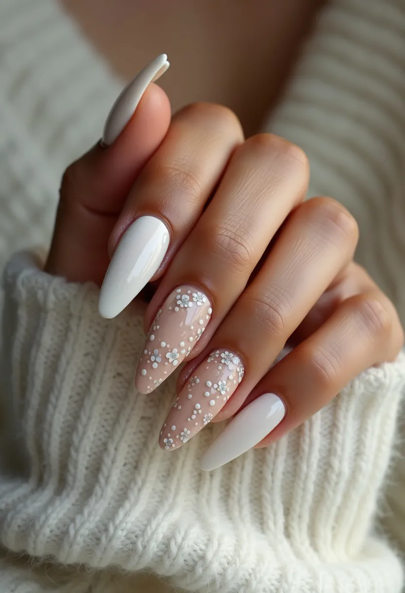 This nail design features a sophisticated and elegant aesthetic, with a color palette consisting primarily of white and nude tones. The nails are shaped in a long, almond style, which adds to their refined appearance. Three of the nails on each hand are painted in a solid white color, providing a clean and classic look. The remaining two nails on each hand have a nude base with intricate white flower decals, adding a touch of delicate artistry. These floral patterns are evenly distributed and include both flowers and dots, giving a slightly raised, textured look. The finish appears glossy, indicating that a gel or shellac nail treatment may have been used to achieve the sleek and shiny appearance. This nail design could be perfect for a springtime event or a formal occasion, given its floral motif and sophisticated style.