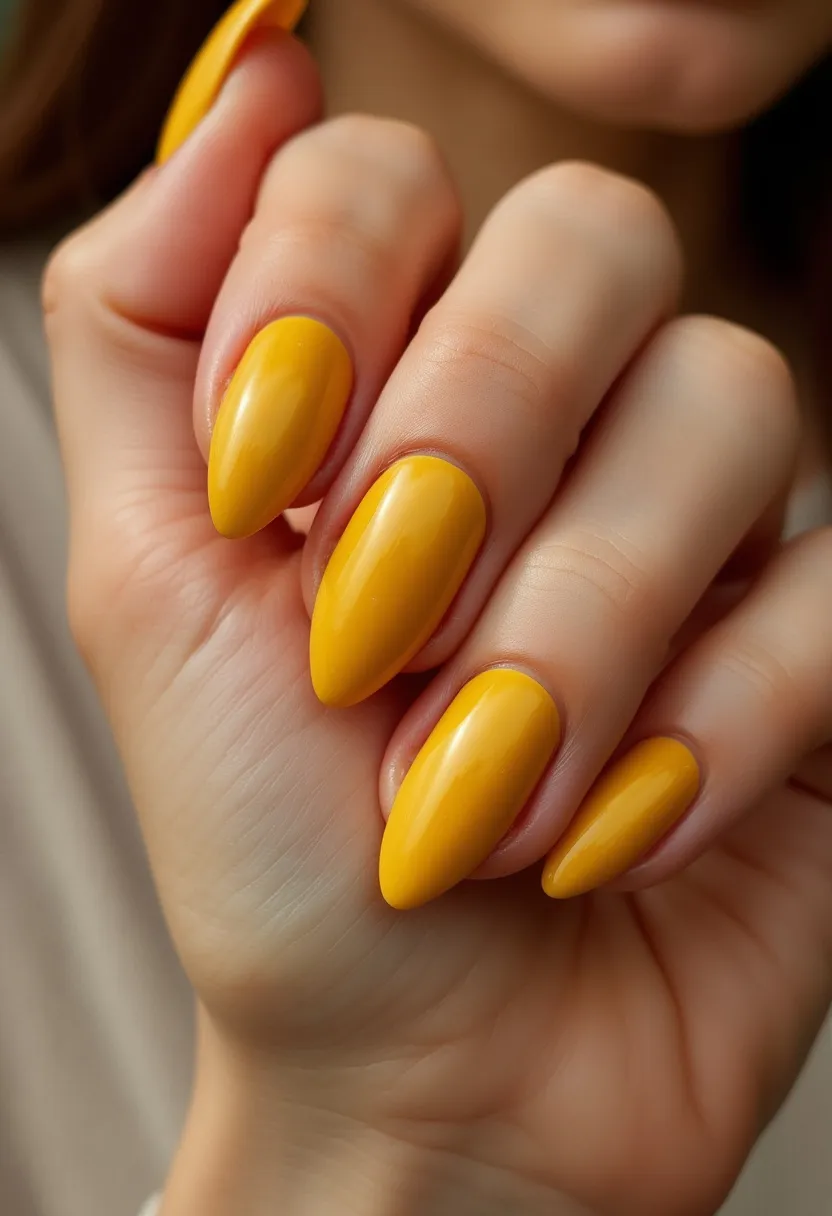 The nail design features a bold and vibrant yellow color palette, showcasing a high-gloss finish indicative of either gel or shellac treatment. The nails are shaped into a stylish almond form, which elongates the fingers elegantly. There are no additional intricate patterns or decorations, allowing the solid yellow color to take center stage. This design is simple yet eye-catching, potentially fitting for spring or summer seasons due to its bright and sunny hue. The treatment appears to be professionally done, given the smoothness and consistency of the polish application.